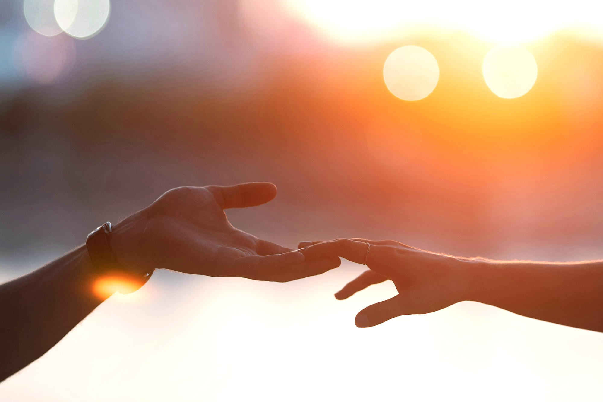 Zwei Hände berühren sich an den Fingerspitzen.